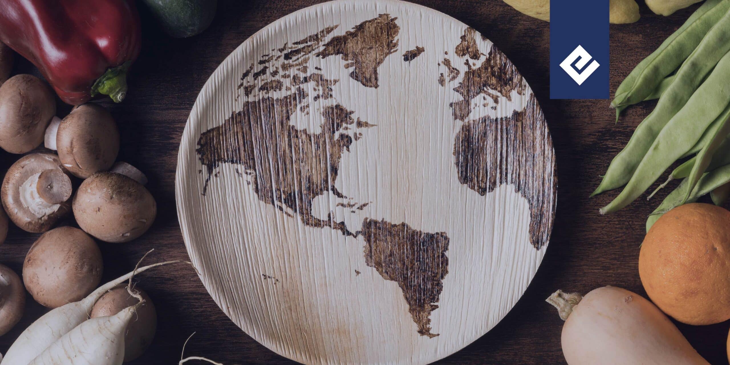 wooden plaque symbolizing the world with fresh food around it to symbolize ESG in the food industry